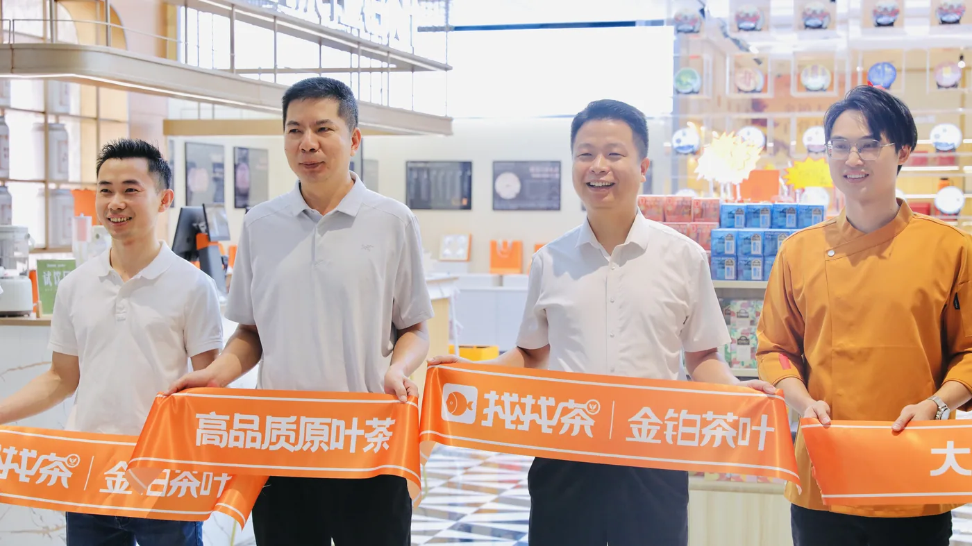 金铂茶叶开业现场,团队手持找找茶与金铂茶叶横幅